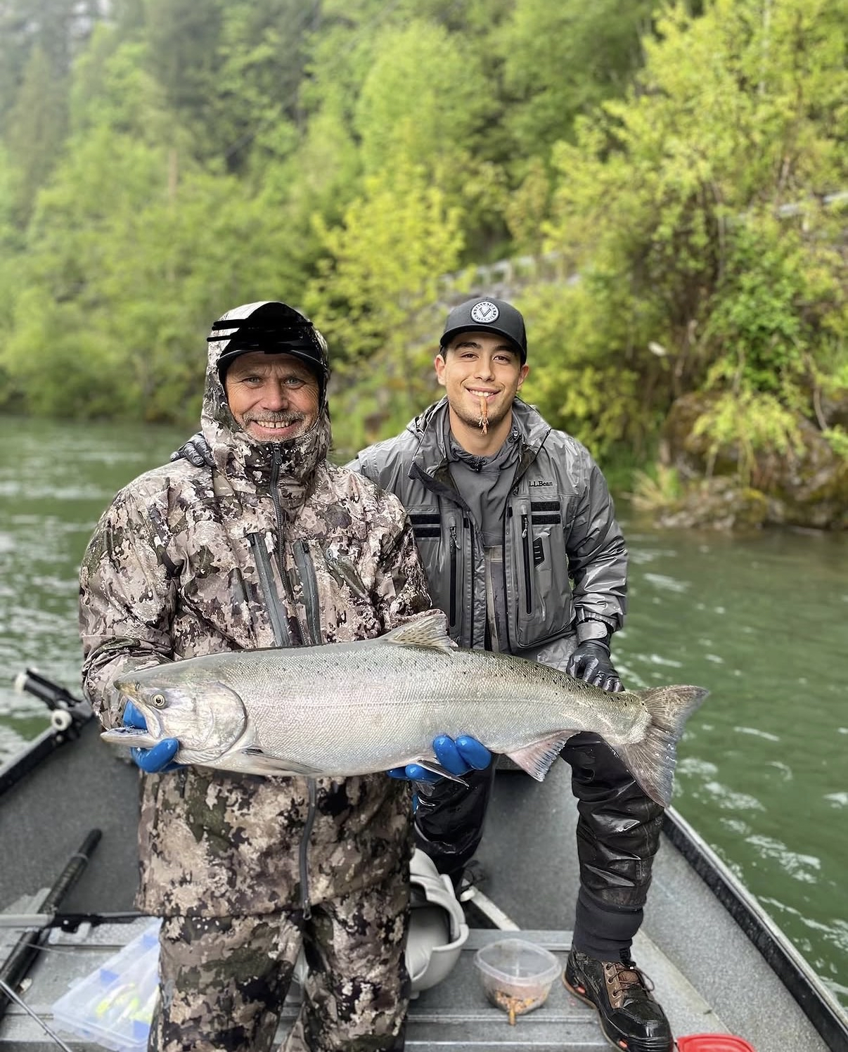 Guide and client on a drift boat with a large salmon