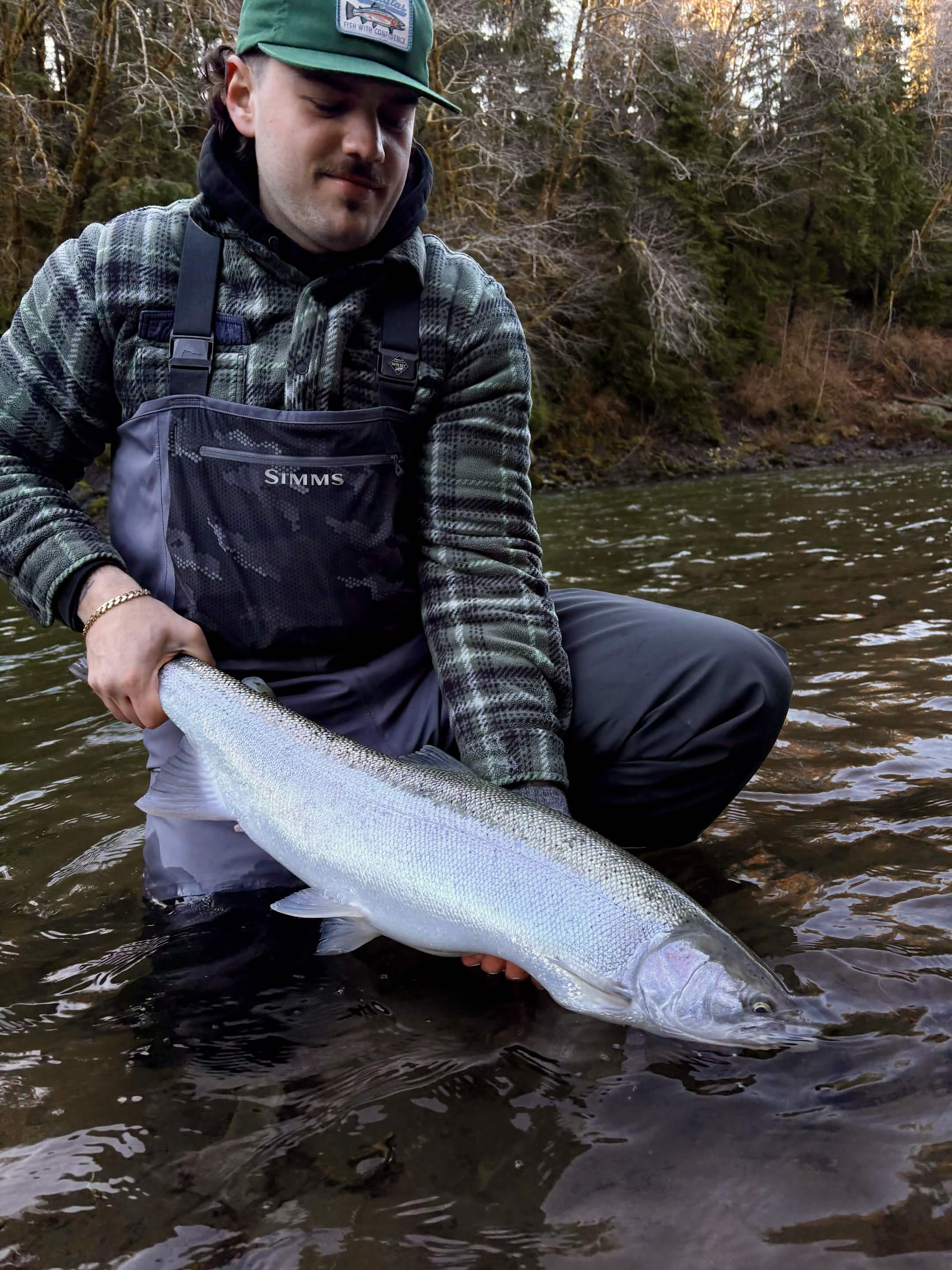 Angler fighting a large fish on a Washington river