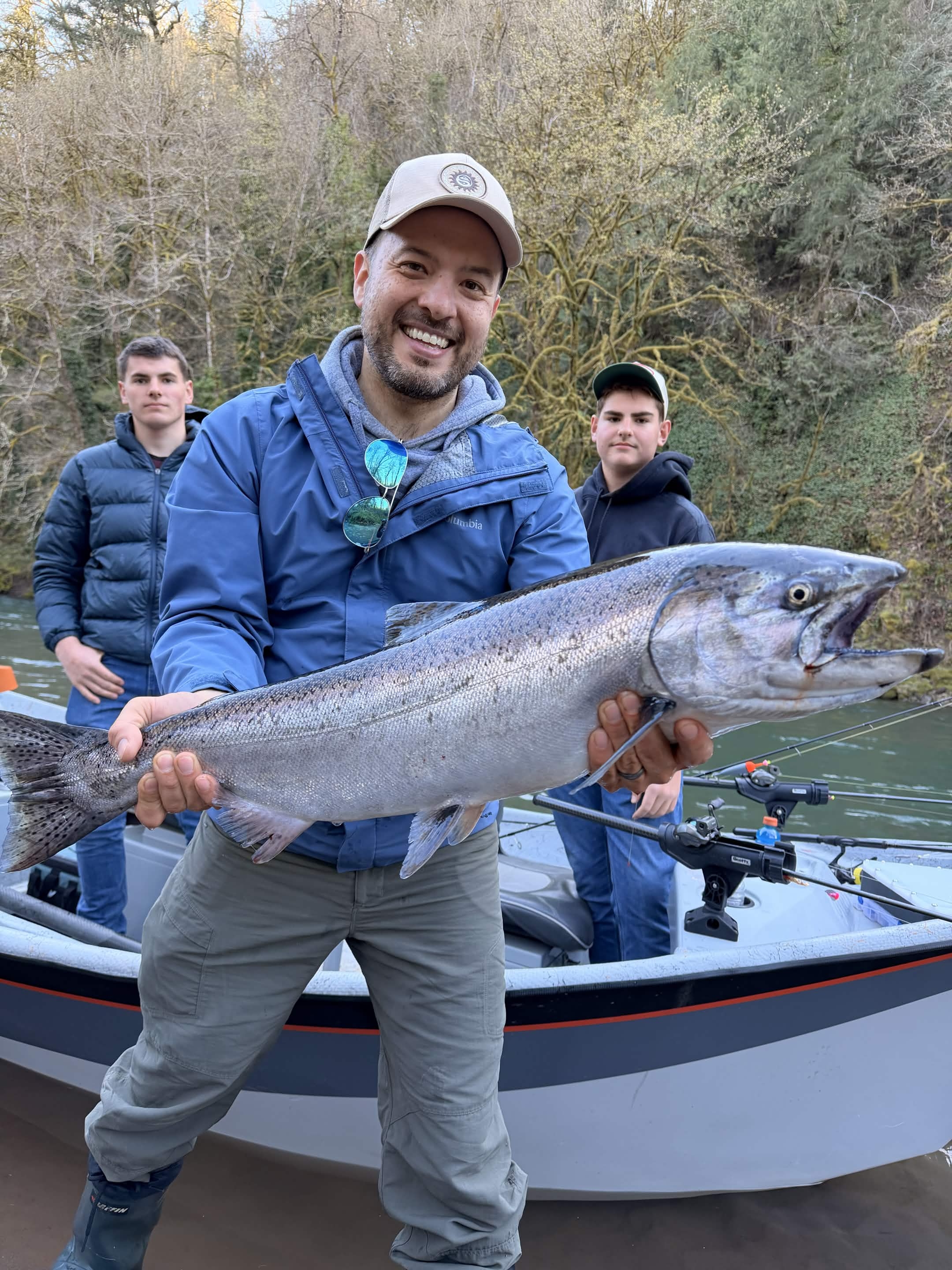 Two anglers on a drift boat with a massive salmon