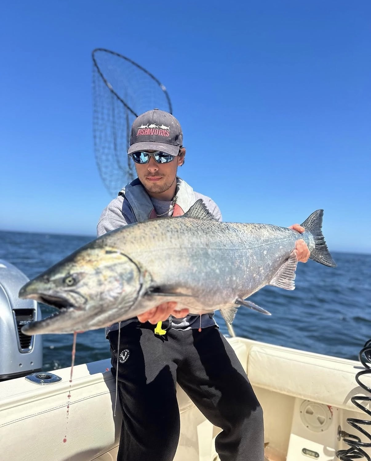 Angler holding a large spring Chinook salmon on a river