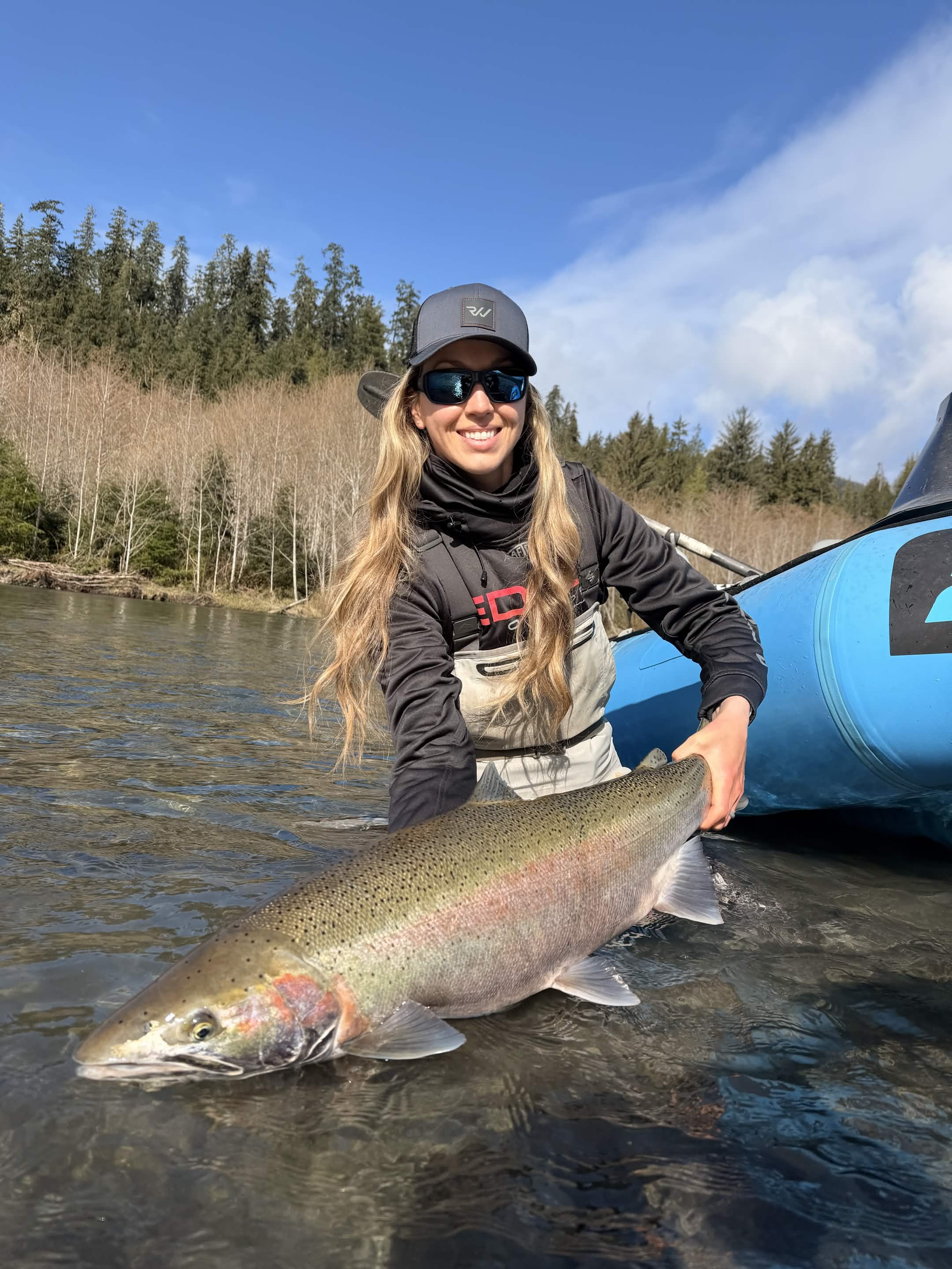 Angler holding a large winter steelhead on a Washington river